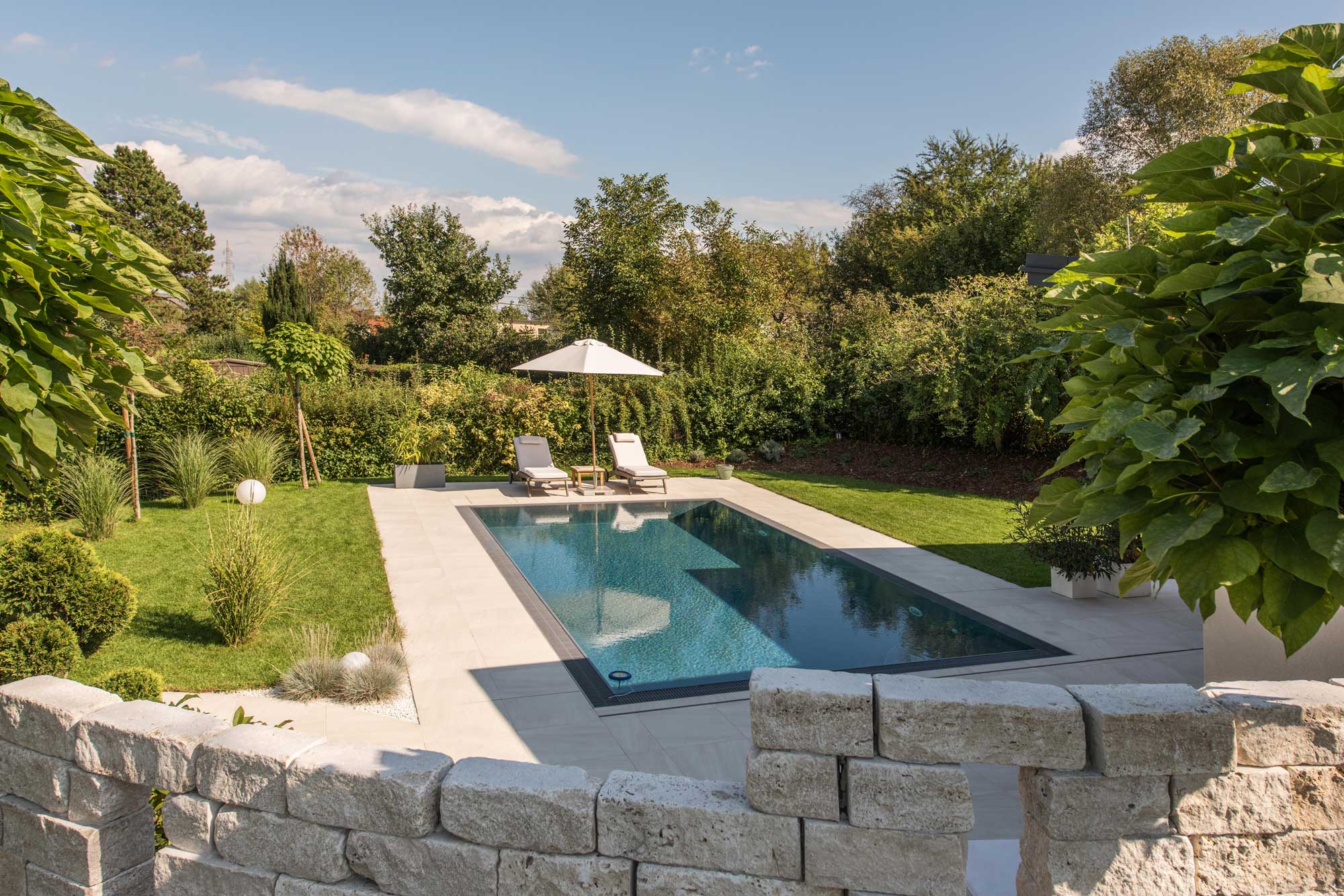 Gestalteter Garten mit Pool, Naturstein und Gartenplatten